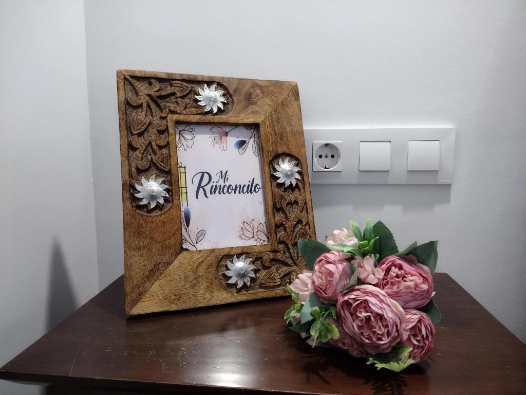 um espelho sobre uma mesa com um vaso de flores em Mi Rinconcito em Baena