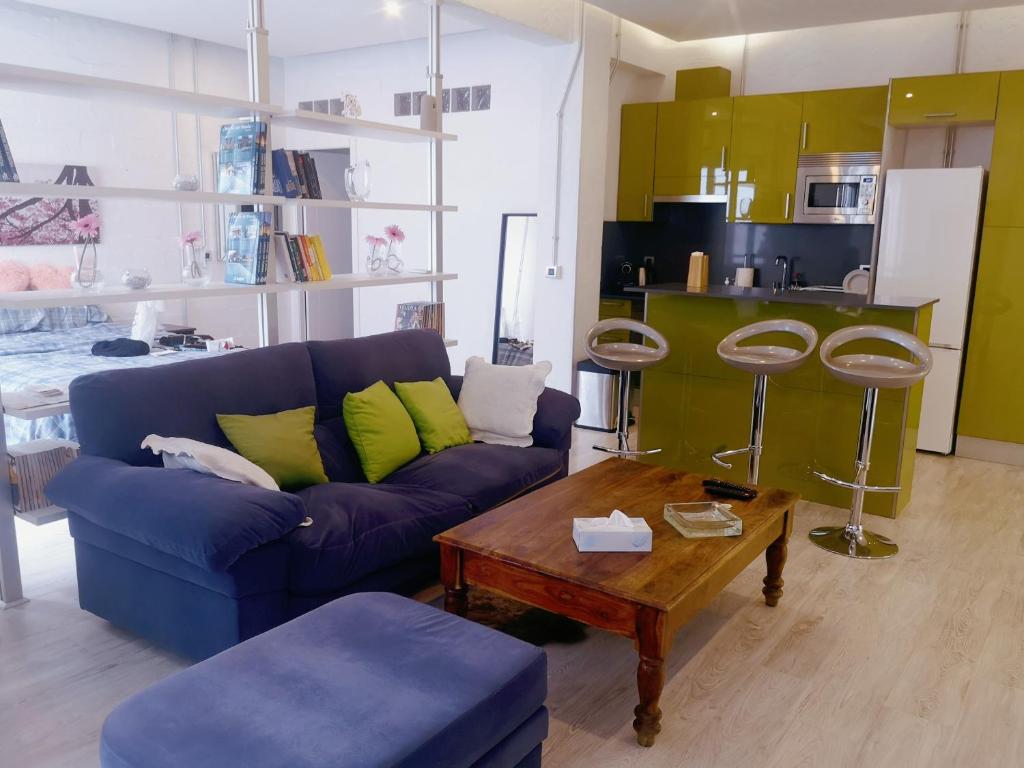 uma sala de estar com um sofá azul e uma mesa em Apartamento Rosa Puerta del Sol em Madrid