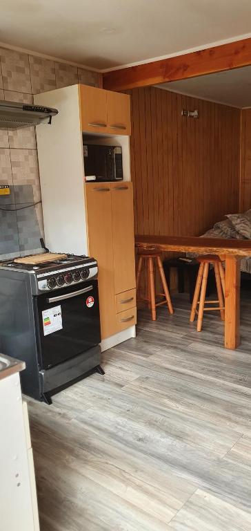 a kitchen with a stove and a refrigerator and a table at El Capitán in Puerto Montt