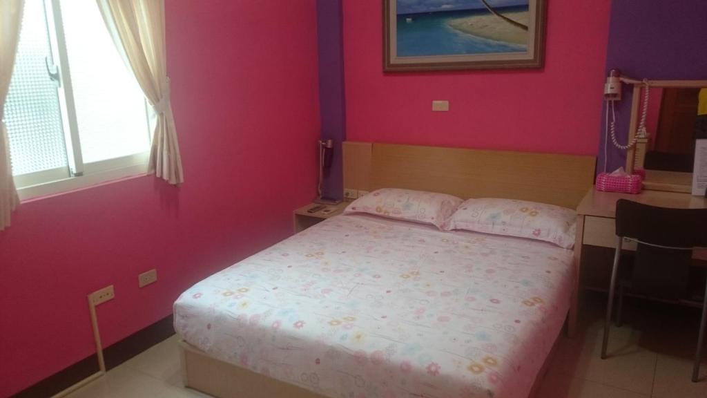 a bedroom with a bed with pink walls at The Beauty of Basalt B&amp;B in Magong