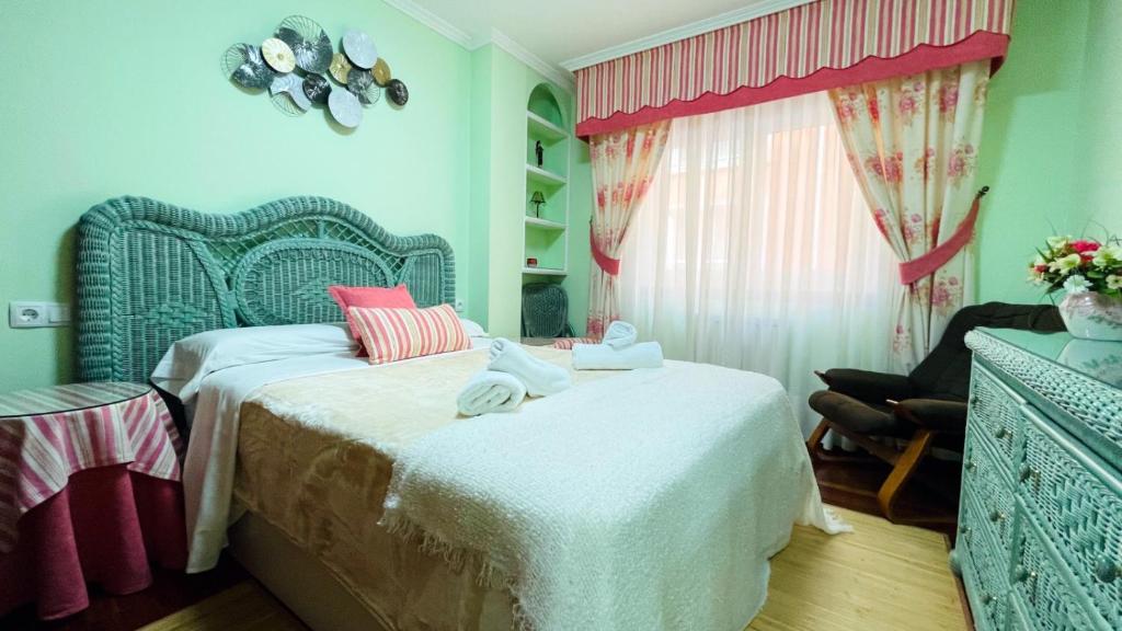 a bedroom with a bed with towels on it at Piso Céntrico Nati Con Parking Incluído in O Grove