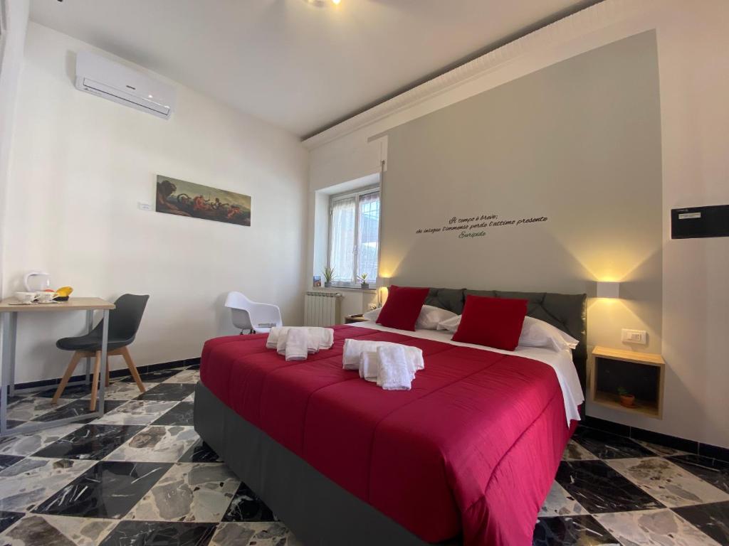 a bedroom with a large bed with a red blanket at Al Teatro Greco in Syracuse