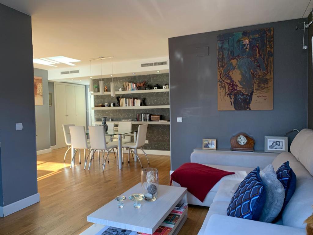 Luxury Aparment in Madrid في مدريد: غرفة معيشة مع أريكة بيضاء وطاولة