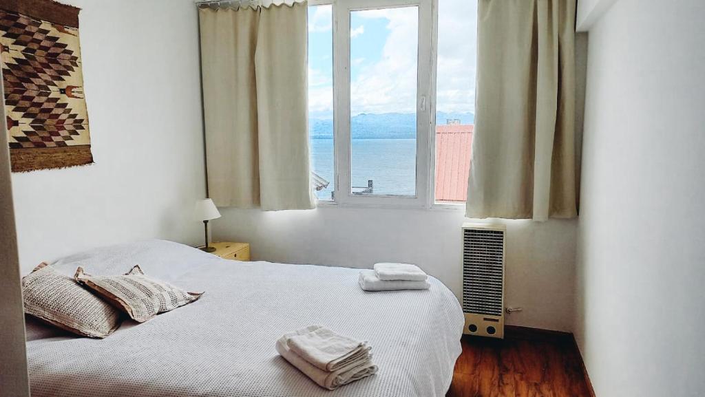 um quarto com uma cama com duas toalhas em Departamento céntrico con vista al lago em San Carlos de Bariloche