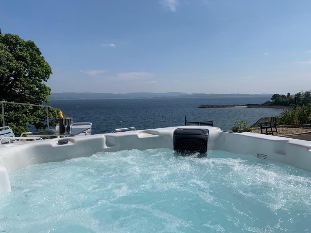 a hot tub with a view of the water at Seaview Cottage in Ascog