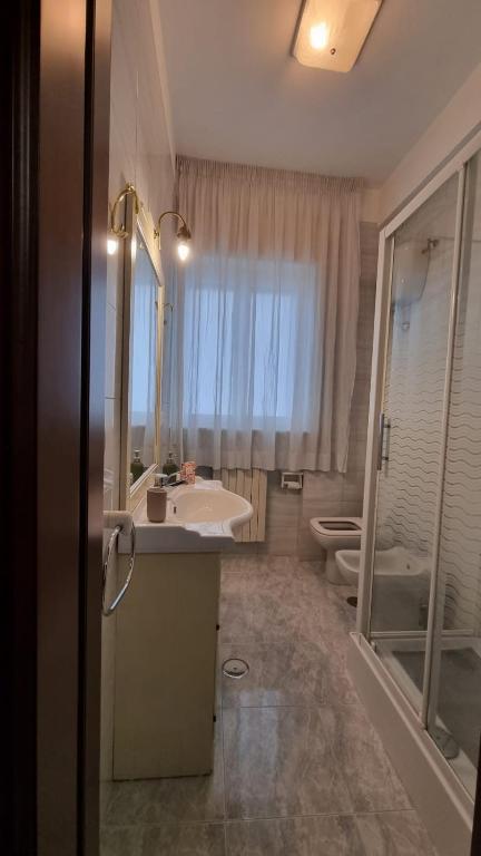 łazienka z umywalką, toaletą i lustrem w obiekcie Casa Bianca B&B w mieście Ostuni