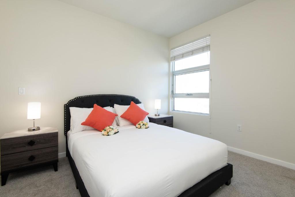 a bedroom with a white bed and a window at ViewPoint Suites in Los Angeles