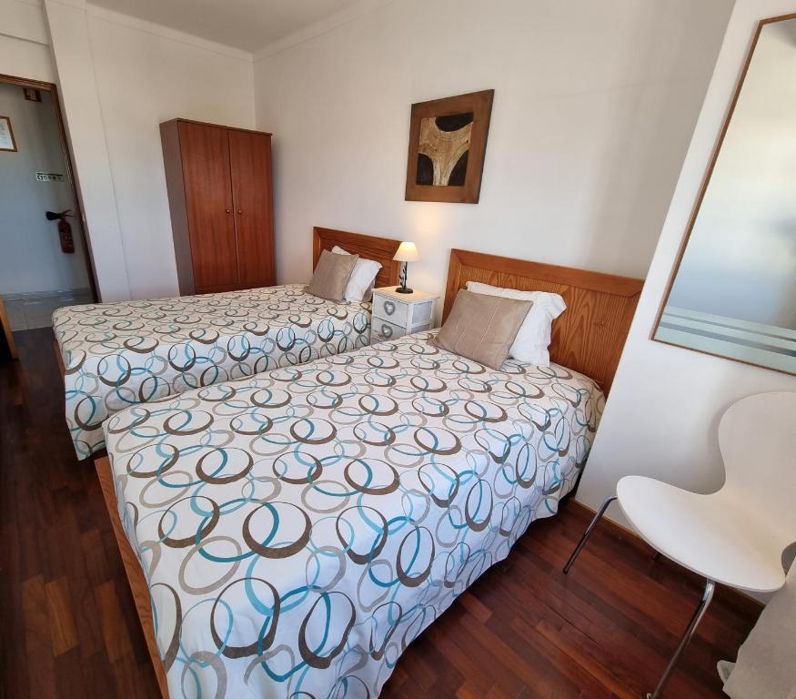 タヴィラにあるApartamento Álvaro de Campos by Homekeysのホテルルーム ベッド2台&椅子付