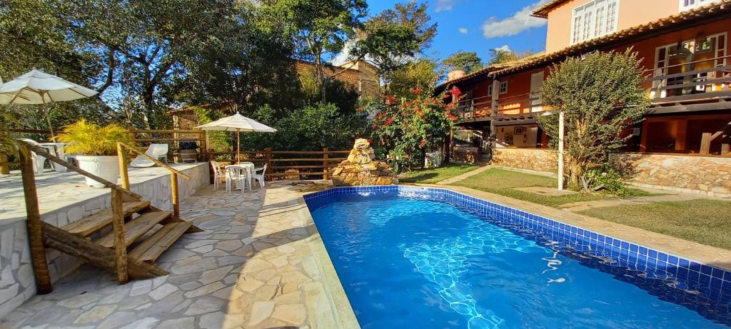 a swimming pool in the backyard of a house at Pousada Canto das Aguas in Serra do Cipo