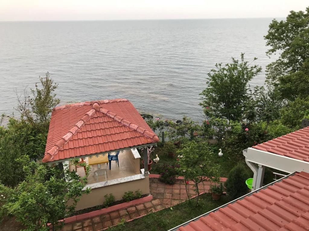 una casa con techo rojo junto al agua en Villa Laila Trabzon, en Trabzon