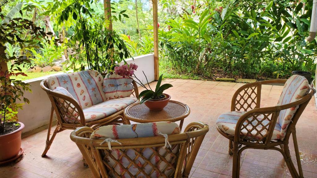 un patio con sedie, divano e tavolo di Appartement d'une chambre avec jardin clos et wifi a Sainte Rose a 2 km de la plage a Sainte-Rose