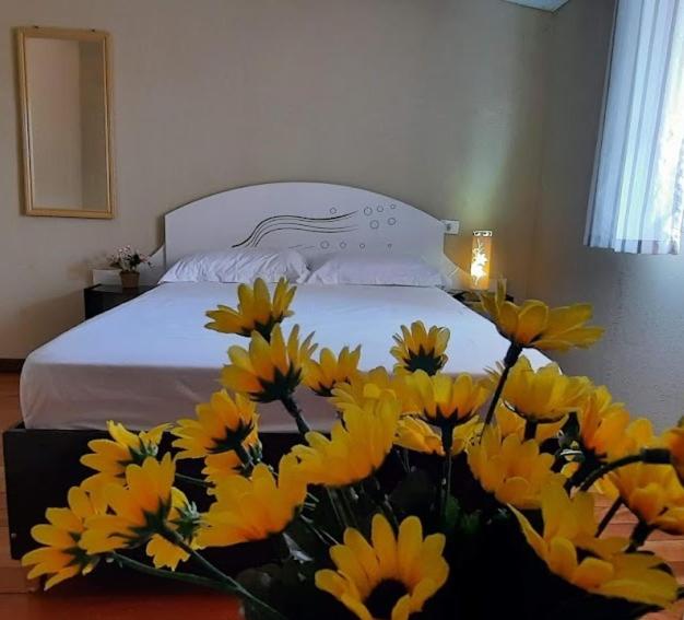 a bed with a bunch of yellow flowers in a room at Loftcharmoso2 in Pinhais