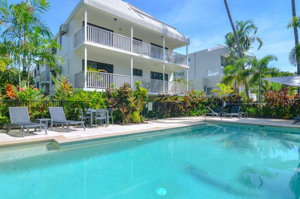 a swimming pool in front of a building at Seascape Holidays - Tropical Reef Apartments in Port Douglas