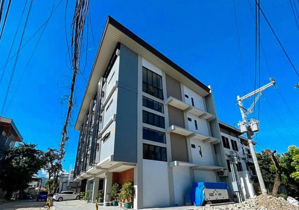 un edificio alto con una grúa delante de él en RedDoorz at Rudhil's Place - Cebu Downtown former RedDoorz near Southwestern University en Cebú