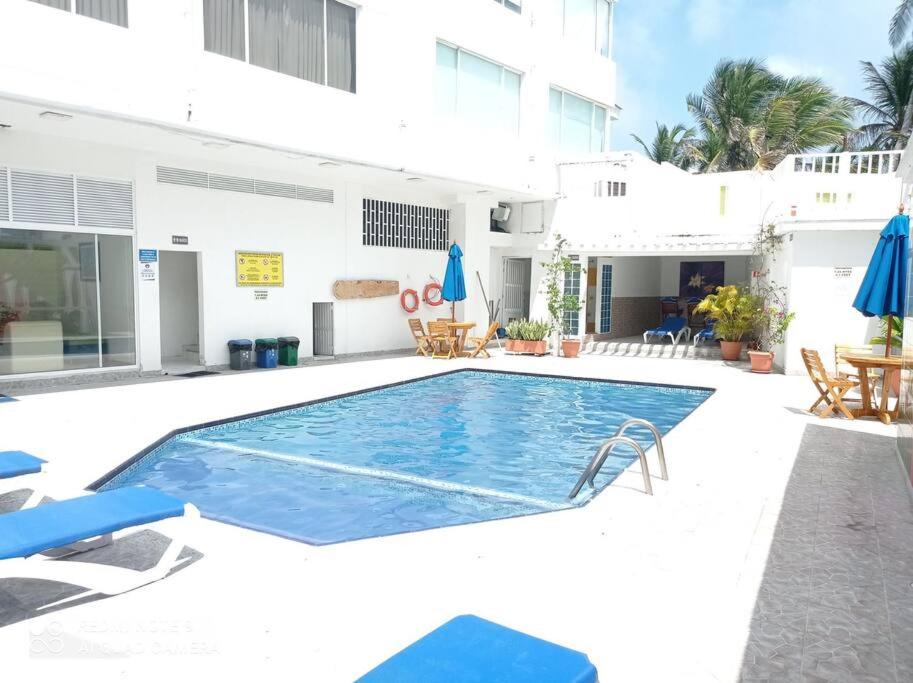 una piscina con sillas azules y un edificio en Lindo apartamento en el mejor sector de la isla. piscina, bbq, playa a 30 metros, en San Andrés