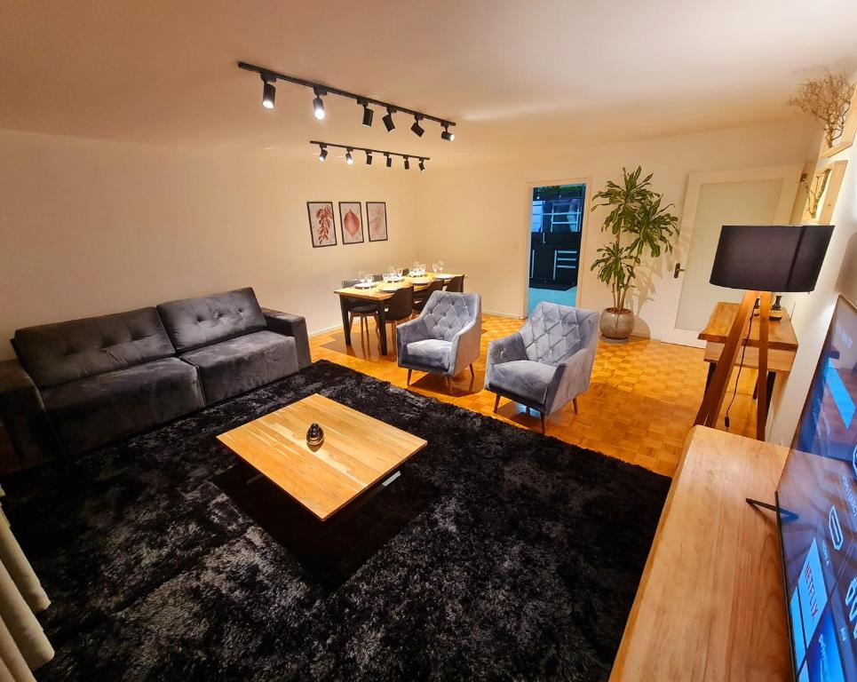 uma sala de estar com um sofá e uma mesa em Apartamento Major Nicoletti em Gramado