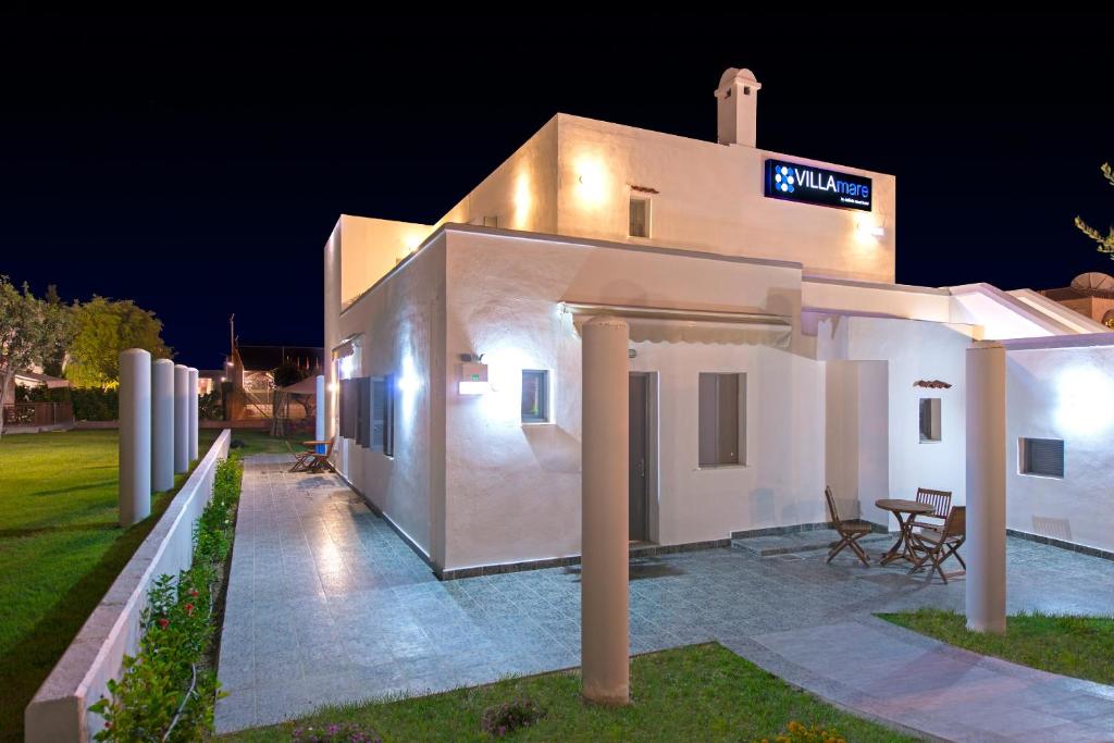 a white house with a sign on it at night at Villa Mare by Delfinia Resort in Kolymbia