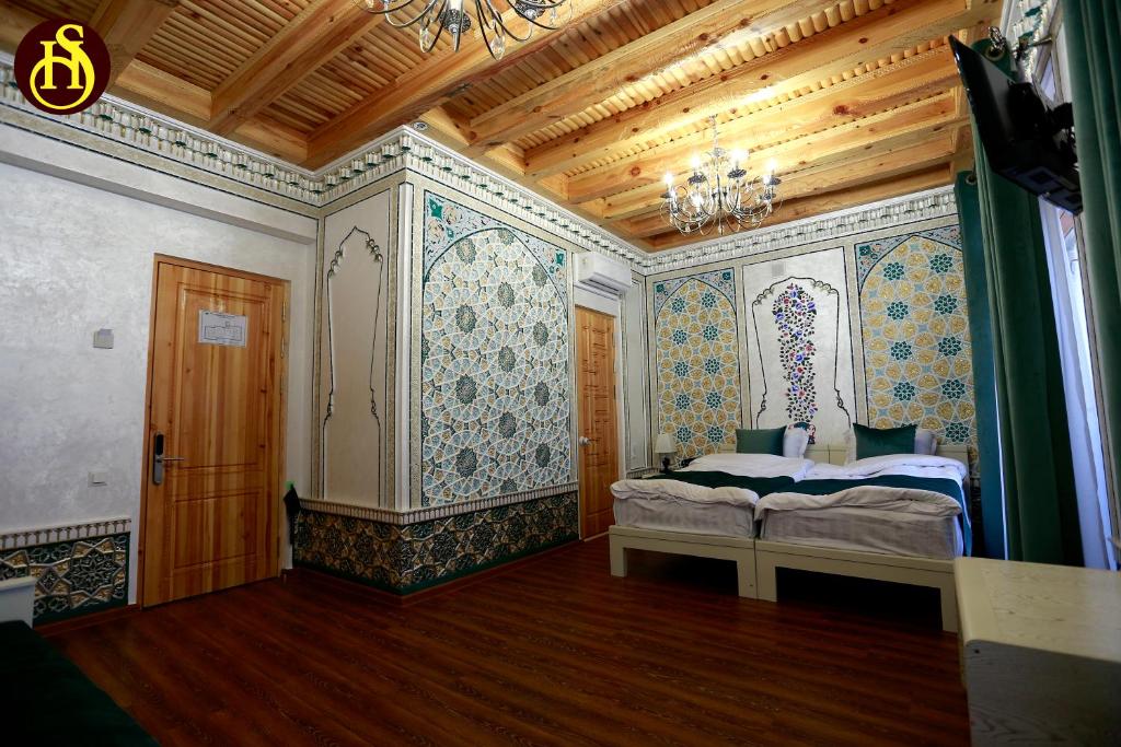 Un dormitorio con una cama en la esquina de una habitación. en Shohnishin Boutique, en Bukhara