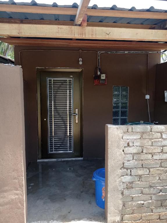 - l'entrée d'une maison avec une porte et une fenêtre dans l'établissement Bonda Guesthouse III, à Paka