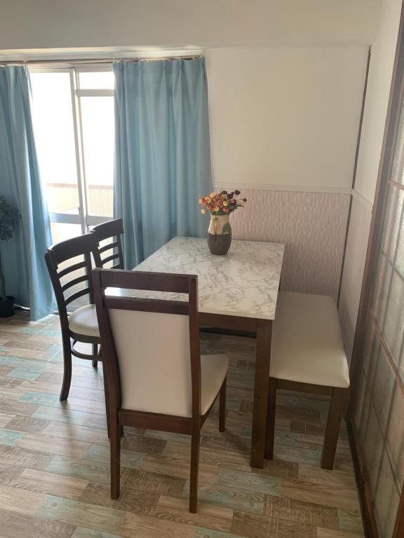 a table and chairs with a vase of flowers on it at 山下ビル307 in Kurosakimachi