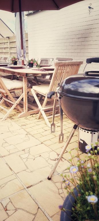 a grill on a patio with a table and chairs at Huize Andries in Bruges