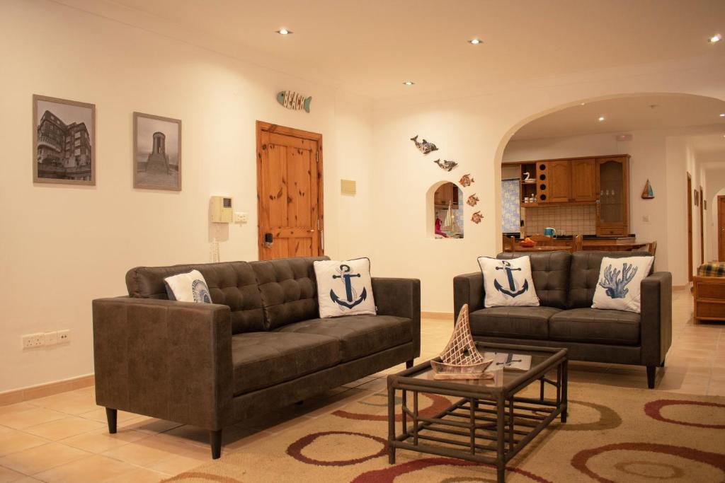 a living room with two couches and a coffee table at Spacious 3 bedroom apartment in Marsascala in Marsaskala