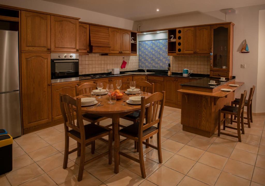 a kitchen with a wooden table and chairs at Spacious 3 bedroom apartment in Marsascala in Marsaskala