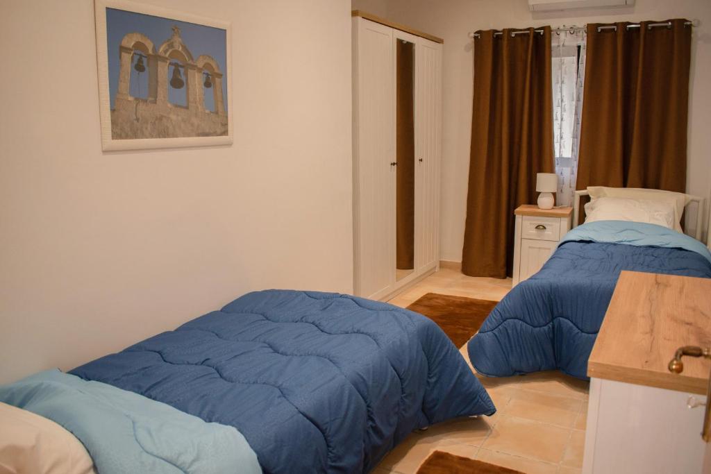 a bedroom with two beds with blue covers at Spacious 3 bedroom apartment in Marsascala in Marsaskala
