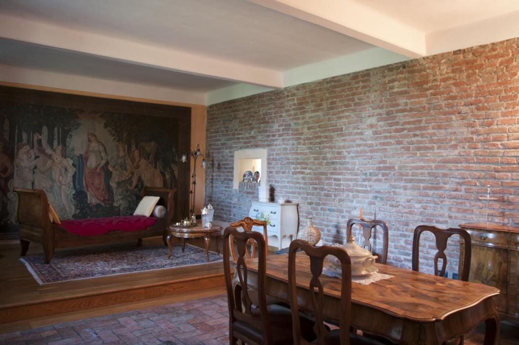 comedor con mesa y pared de ladrillo en B&B Corte Leopoli, en Buscoldo