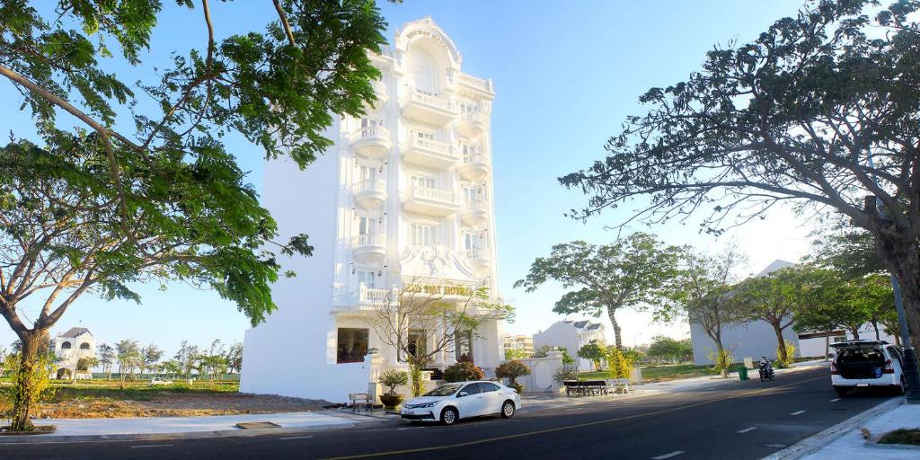 潘切的住宿－Huy Đạt Hotel，停在大楼前的白色汽车