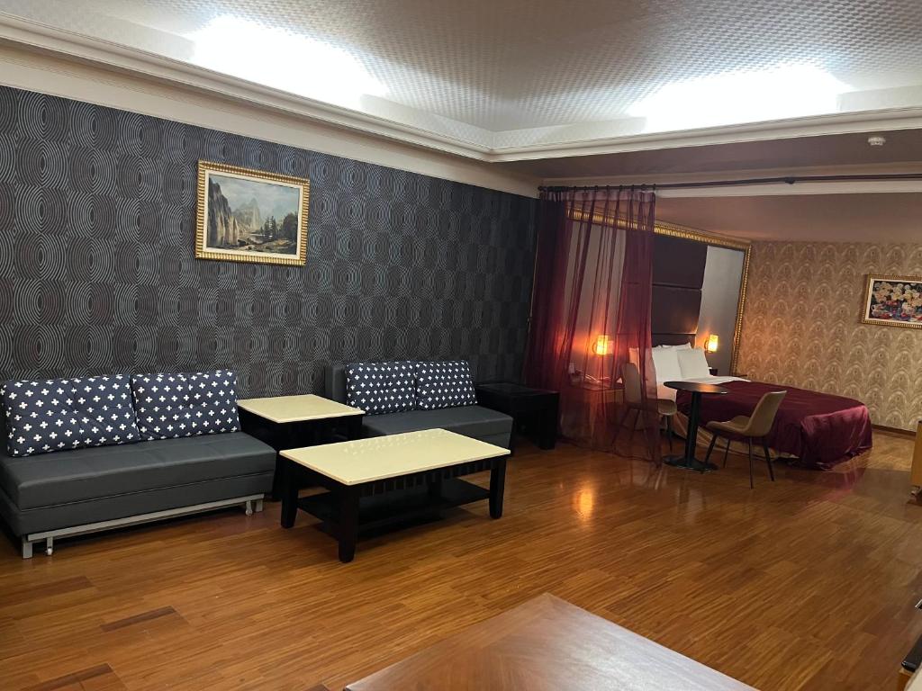a living room with a couch and a table and a desk at Hua Xiang Motel - Fengshan in Kaohsiung
