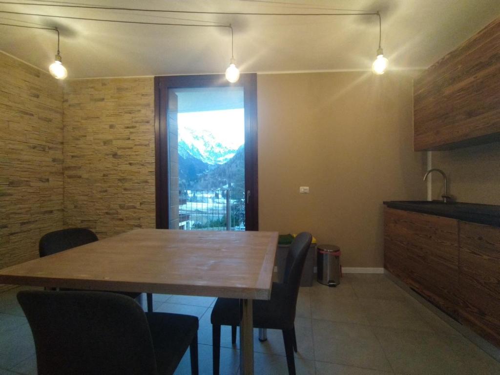comedor con mesa de madera y sillas en GRAYNITE-Adamello Peak Apartments, en Temù