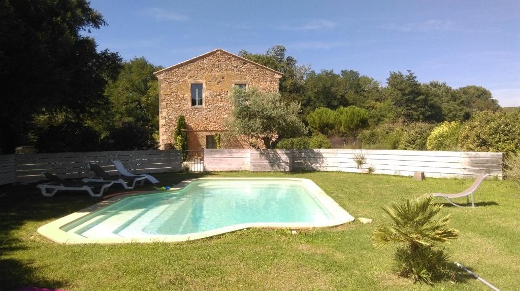 a small swimming pool in the yard of a house at Gites la Filature in Laudun