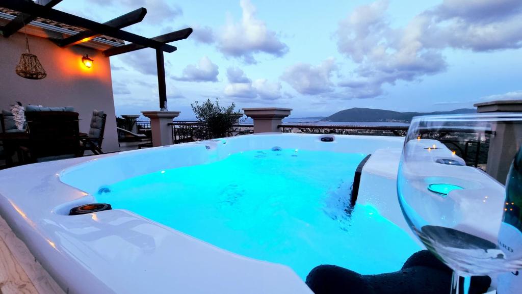 a hot tub with a glass of wine and a glass of water at Aquilina in Apolpaina