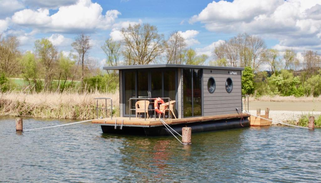 a small house on a dock in the water at Hausboot Schwanennest in Kirchberg an der Raab