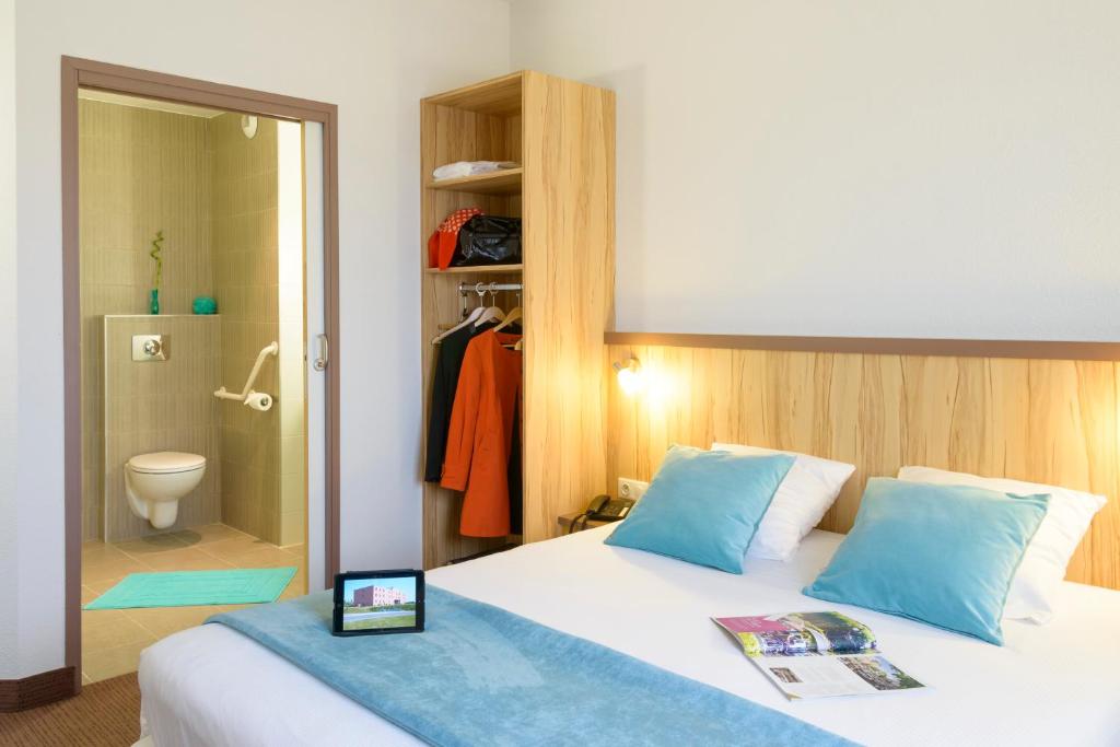 a bedroom with a bed and a bathroom with a shower at Brit Hotel Reims Croix Blandin in Reims