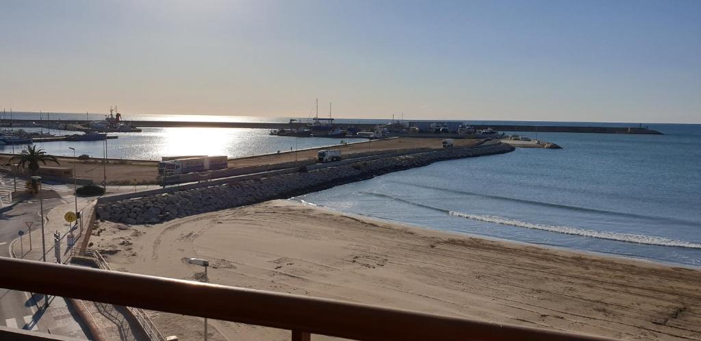 una vista su una spiaggia con il sole che riflette nell'acqua di vinaros playa de arena a Vinarós