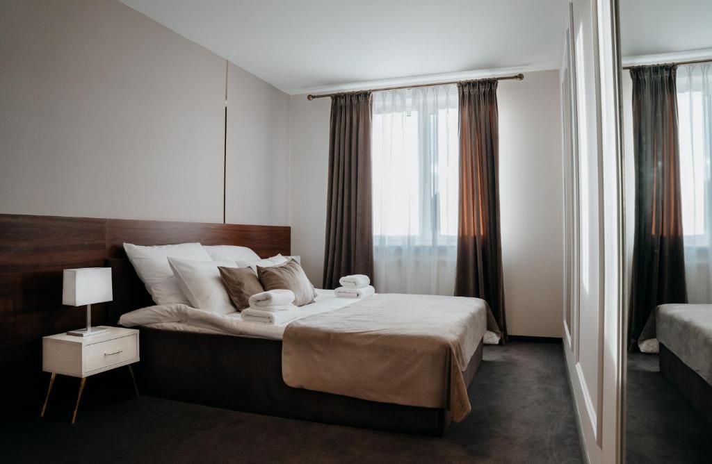 ein Schlafzimmer mit einem großen Bett und einem großen Fenster in der Unterkunft Hotel Resident in Nowa Sarzyna