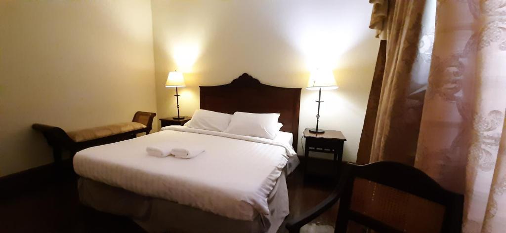 a bedroom with a white bed with two towels on it at Hotel Salcedo De Vigan in Vigan