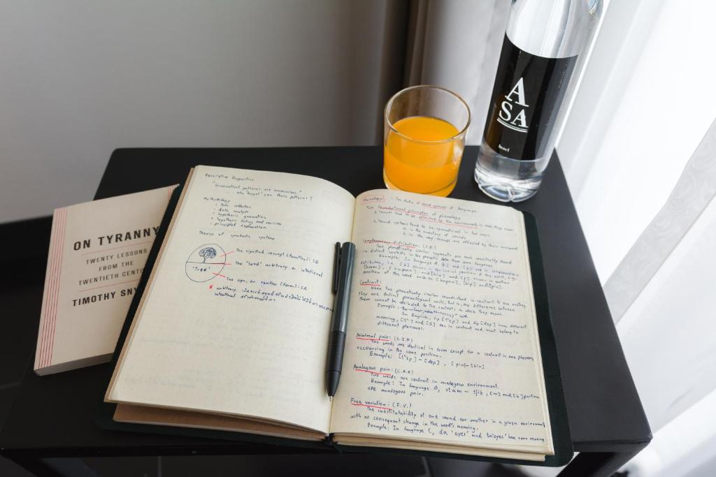 A black table beside a bright window is set up for reading or writing.
