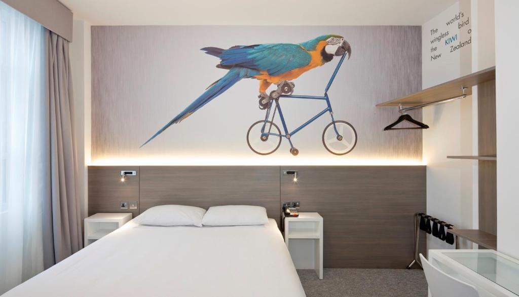 a bird perched on top of a bed in a bedroom at Heeton Concept Hotel - Kensington London in London