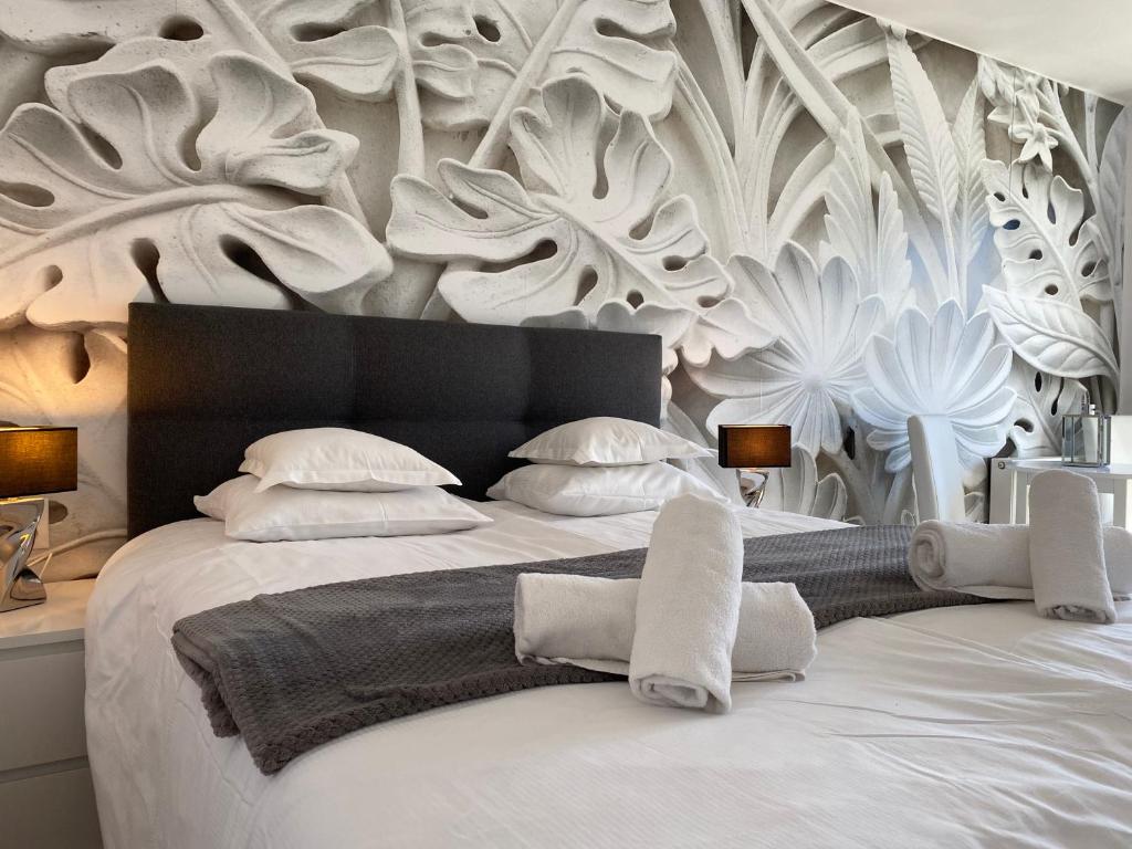 1 dormitorio con 1 cama blanca grande con flores blancas en la pared en Pokoje Gościnne Akwatel, en Jastarnia