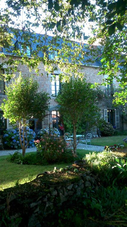 a large brick building with trees in front of it at La Demeure du Collectionneur in Quintin