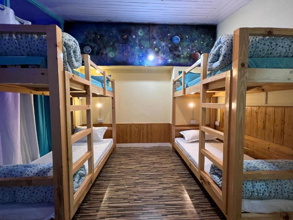 a bunk bed room with three bunk beds at The Vagabond Manali in Manāli