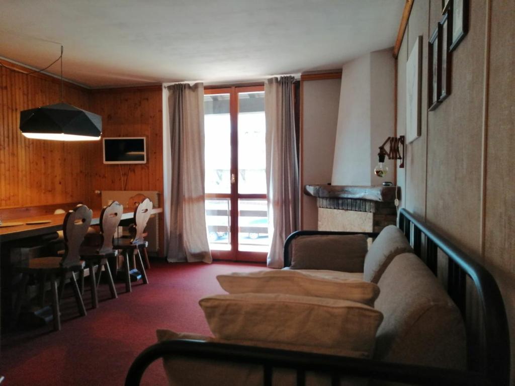 salon z kanapą i stołem z krzesłami w obiekcie DONCIO`S Ski Hike & Bike Apartment w mieście Passo del Tonale