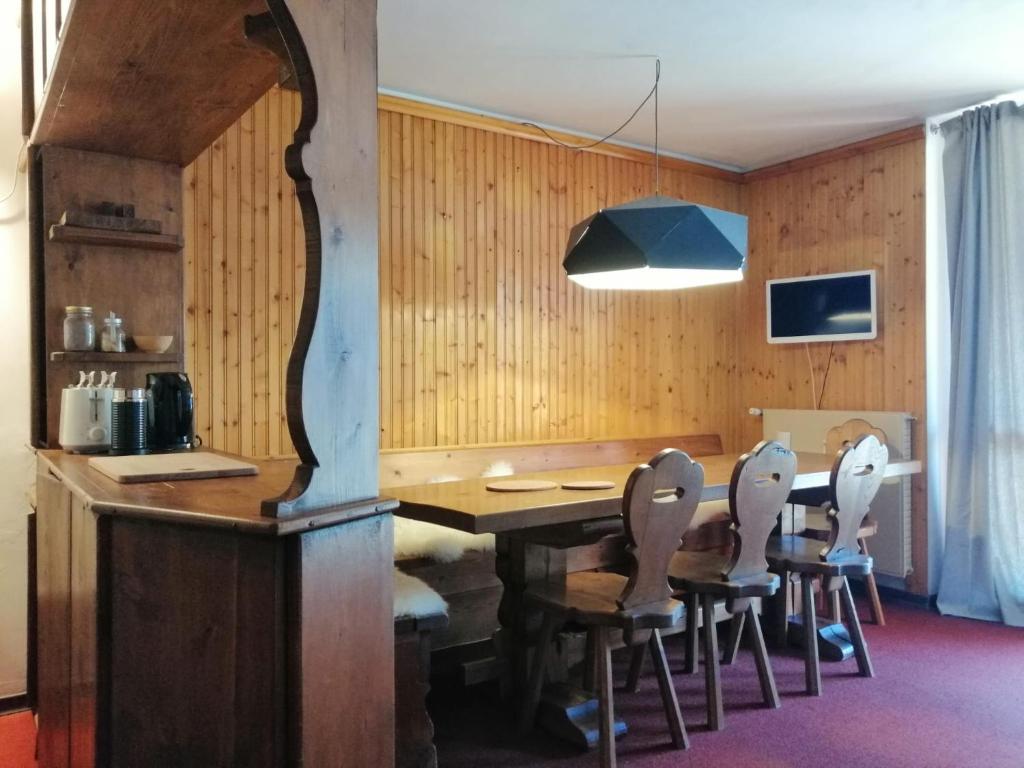 jadalnia z drewnianym stołem i krzesłami w obiekcie DONCIO`S Ski Hike & Bike Apartment w mieście Passo del Tonale