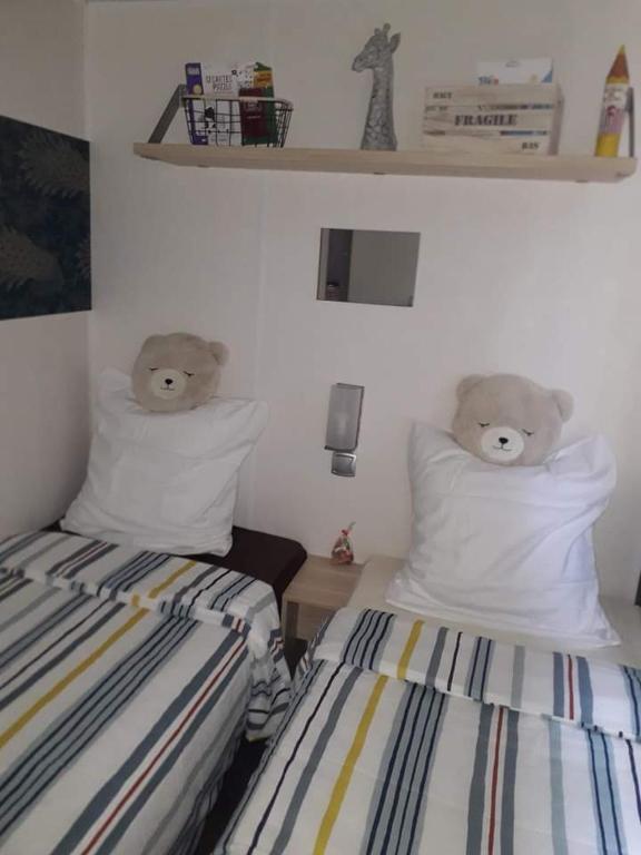 - 2 lits jumeaux avec des ours en peluche sur les oreillers dans l'établissement Anne Marie vous accueilles dans son logement familiale pour 6 personnes 3 chambres confortable proche d Europa Park a BOOFZHEIM dans CAMPING 3 Etoiles, à Boofzheim