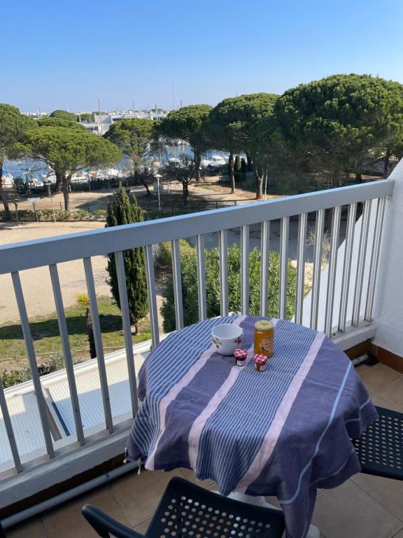a table on a balcony with a bowl of food at Studio vue port, parking privé, terrasse, clim in Le Grau-du-Roi