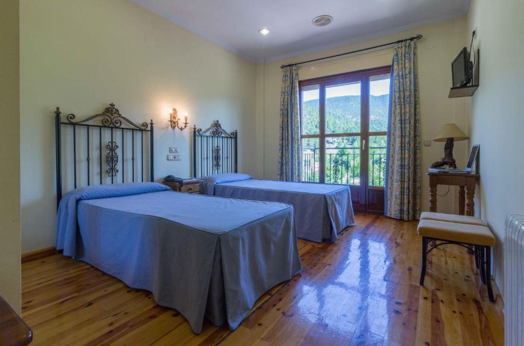 - une chambre avec 2 lits et une grande fenêtre dans l'établissement Hotel Riopar Spa, à Riópar