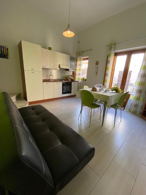 salon z kanapą i stołem z krzesłami w obiekcie Appartamento Casa Trento w mieście Castellammare del Golfo